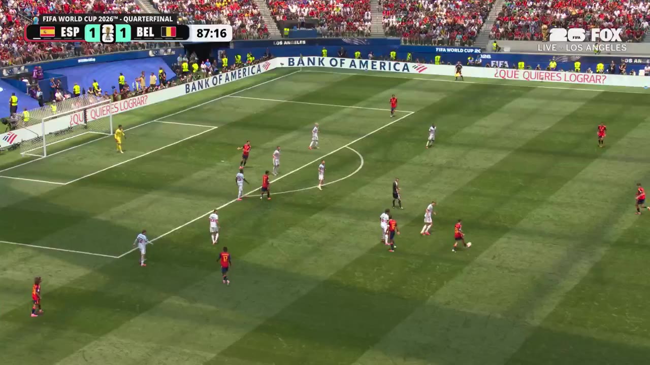 Soccer match with scoreboard reading FIFA WORLD CUP 2026 QUARTERFINAL, ESP 1-1 BEL then ESP 2-1 BEL, clock around 87:20-87:29; a goalkeeper in yellow dives as a shot goes in, then two Spain players in red jerseys embrace in celebration, one numbered 17 with name WILLIAMS JR and another with LAMINE YAMAL on the back.