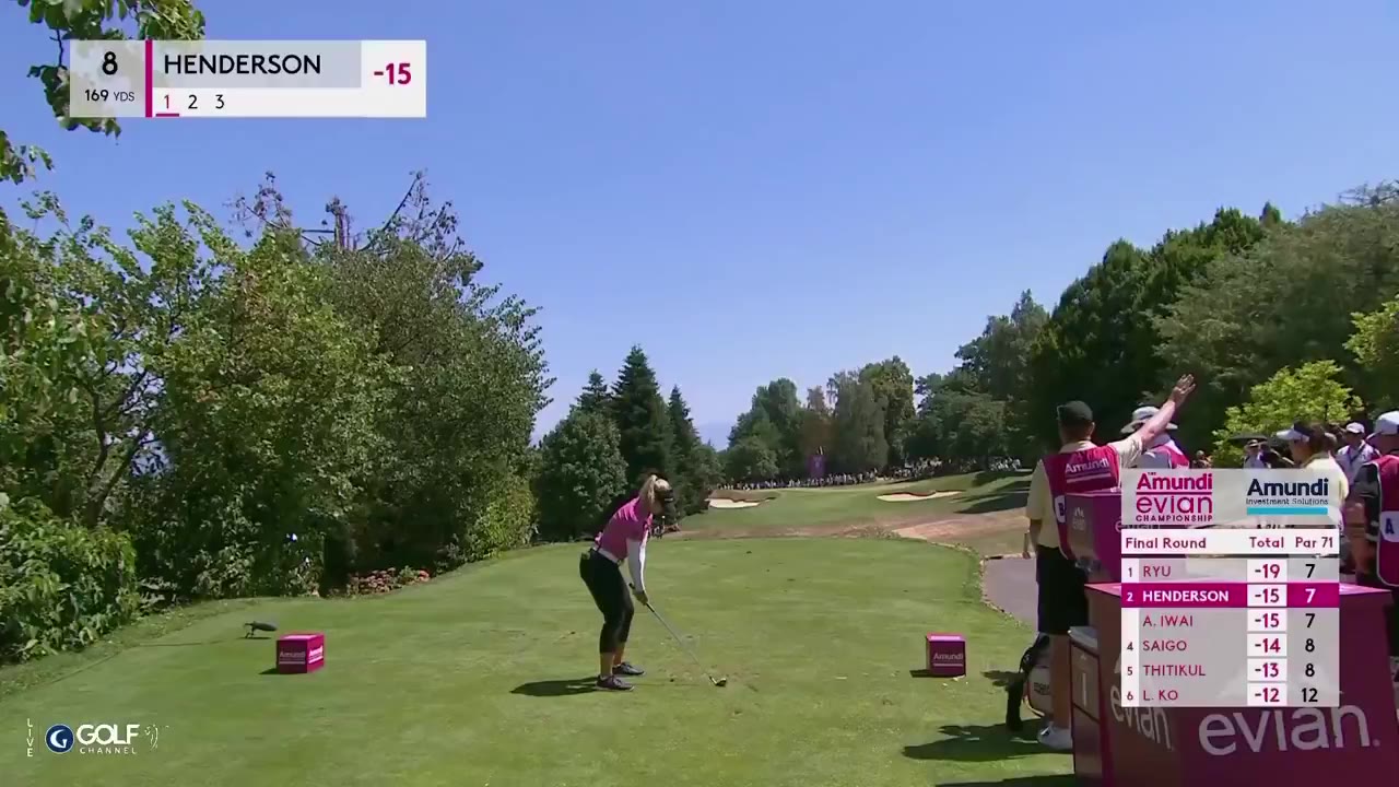 A golf ball rolls into the cup on a green next to a bunker; a live Evian Championship Final Round leaderboard overlay shows Ryu at -19, Henderson at -15/-17, then a woman in a pink checkered CPKC polo and visor smiling and celebrating near the tee.