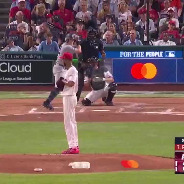 A pitcher on the mound in a white Phillies home uniform delivers a pitch as a batter in a gray New York road jersey swings; a later shot shows infielders positioned in the outfield grass with a runner rounding the bases, then a Yankees baserunner in helmet and gray road jersey smiling at first base near an umpire.