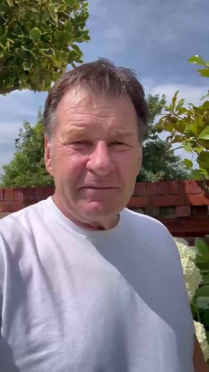 A man in a white t-shirt stands outdoors in front of trees and a brick wall, speaking directly to the camera with captions reading 'So anyway, the Bryson thing,' then 'he hasn't shown much strategy on a links golf course,' then 'Strategy will be key to becoming Champion Golfer of The Year.'