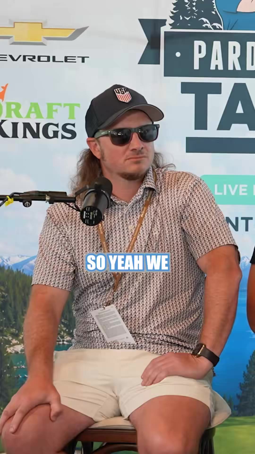 A bald man in a light-yellow striped polo sits for a podcast interview in front of a 'Pardon My Take' branded backdrop, speaking into a microphone with captions reading 'FOR AARON,' 'TO TELL PEOPLE,' and 'THE LOCKER' displayed on screen.