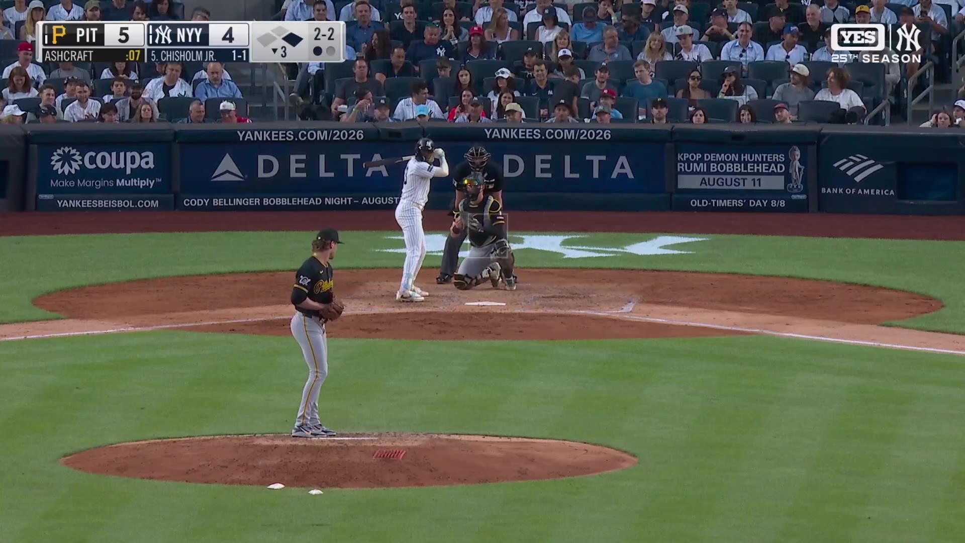 A pitcher in a gray road uniform delivers a pitch, then a Yankees player in pinstripes rounds the bases pumping his fist and pointing skyward after hitting a home run, with the scoreboard showing PIT 5 NYY 4 and an on-screen graphic reading Jazz Chisholm Jr., 16th HR of season, 2nd today.