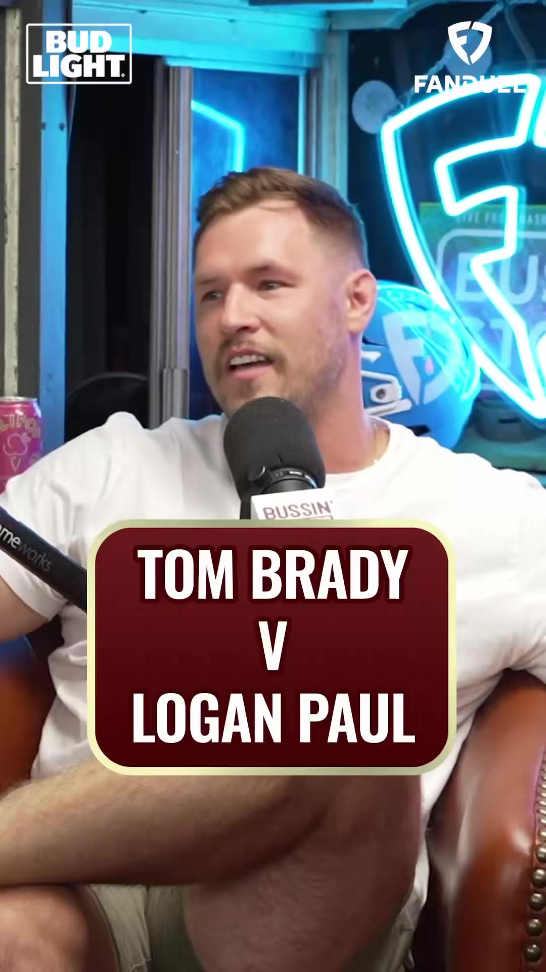 A Bussin' With The Boys podcast clip cutting between two hosts talking into a branded microphone and an inserted WrestleMania photo of a shirtless man with a bun carrying another man over his shoulders in the ring, with on-screen caption text reading 'I BELIEVE... THIS WOULD BE... SUPER BOWLS.'