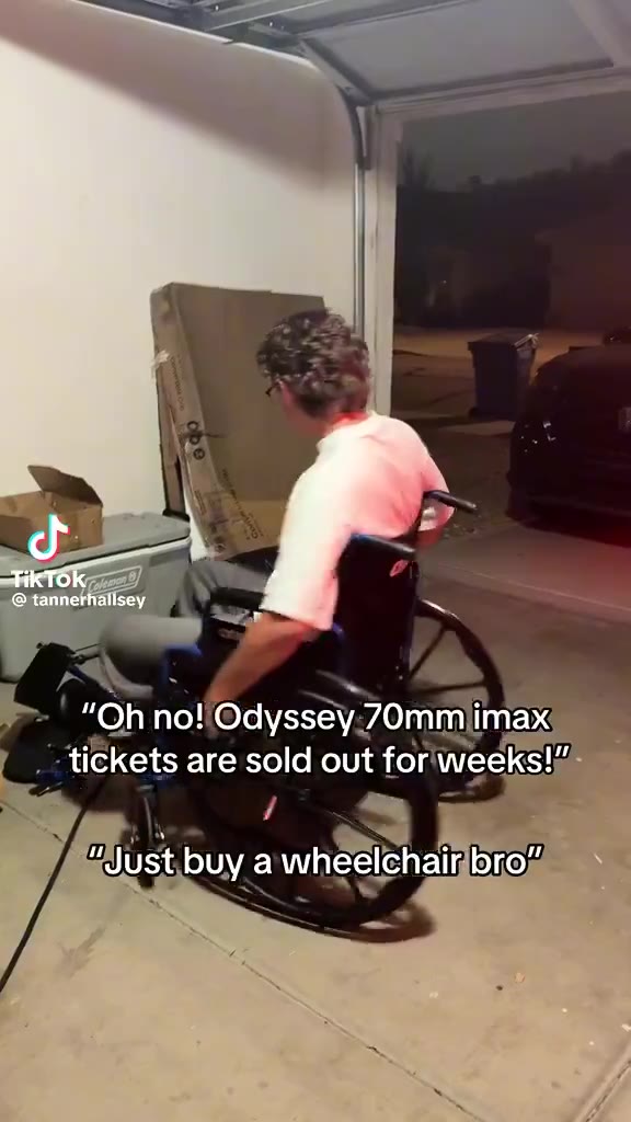 A TikTok clip shows a person on roller skates being pushed in a wheelchair through a parking lot at night; on-screen text reads quoted dialogue about sold-out IMAX tickets and buying a wheelchair instead.