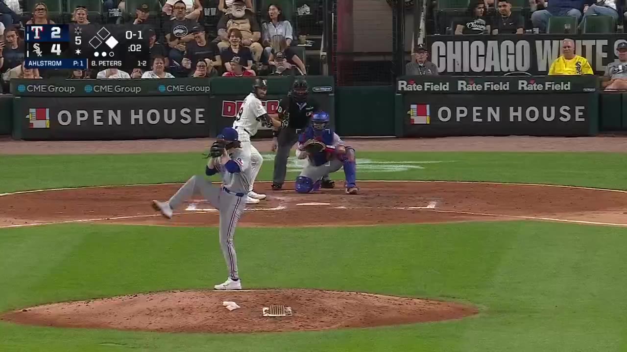 A White Sox player, jersey number 29, rounds the bases with fists raised after a home run in a night game; the outfield stands show fans reacting near the wall, and the scoreboard reads Rangers 2, White Sox 4, with batter listed as B. Peters.