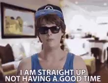 A young man wearing sunglasses and a baseball cap gestures with both hands while a text overlay reads "I AM STRAIGHT UP NOT HAVING A GOOD TIME" across all three frames, indoors in what looks like a house.