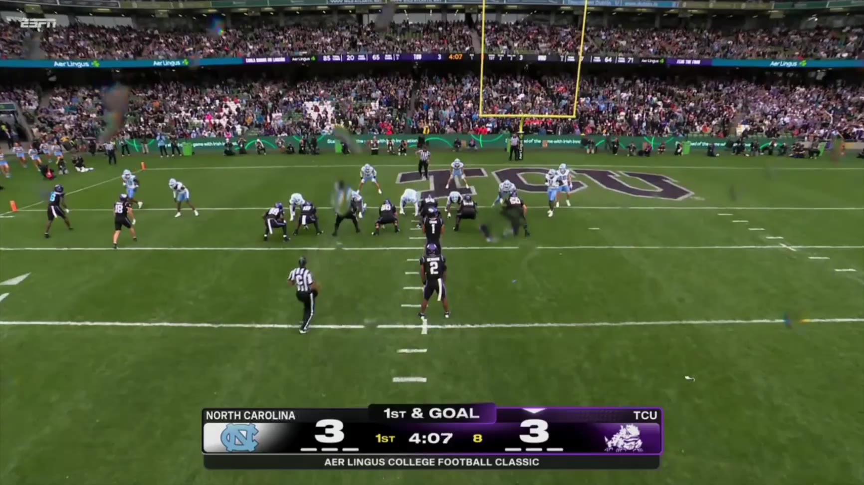 TCU offense in black jerseys runs a goal-line play against North Carolina in light blue jerseys near the TCU end zone logo, followed by TCU players celebrating with a scoreboard showing TCU 9, North Carolina 3 and an on-screen graphic crediting Jon Denman with a 2-yard rushing touchdown.