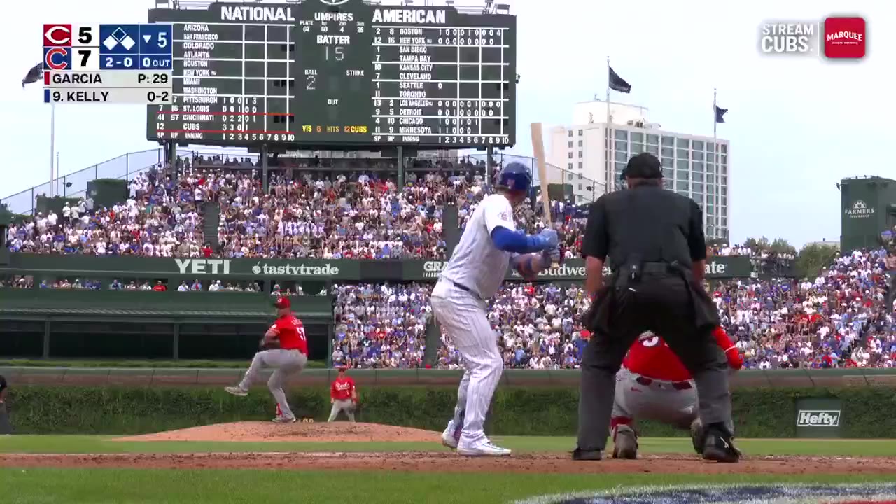 Cubs player rounding third base after a home run at Wrigley Field, scoreboard shows Cubs leading 7-5 in the bottom of the 5th inning against a team with a red script C logo
