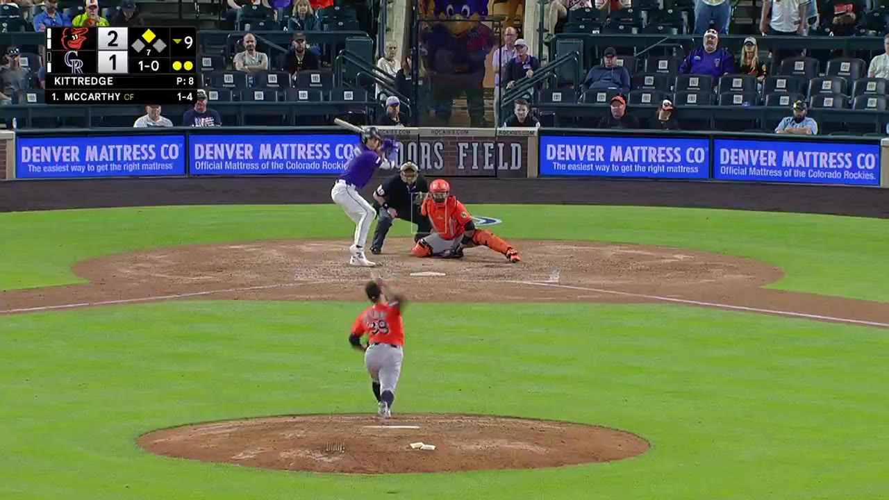 An Orioles outfielder in a gray road jersey leaps and crashes into the outfield wall making a catch at Coors Field, with the scoreboard showing Orioles 2, Rockies 1 in the bottom of the 9th; a following frame shows Orioles players celebrating with a FINAL score of Orioles 2, Rockies 1.