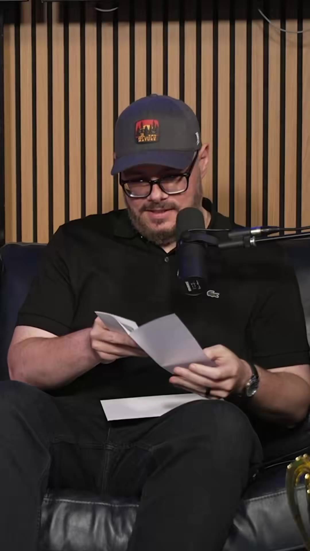 A man wearing glasses and a cap holds folded index cards and reads from them near a podcast microphone, with on-screen text reading FOOTBALL WRITER and ANALYSIS; a separate clip shows a different man at a desk with a podcast microphone reading FOR WINNING on screen, with sports memorabilia and a laptop covered in stickers behind him.