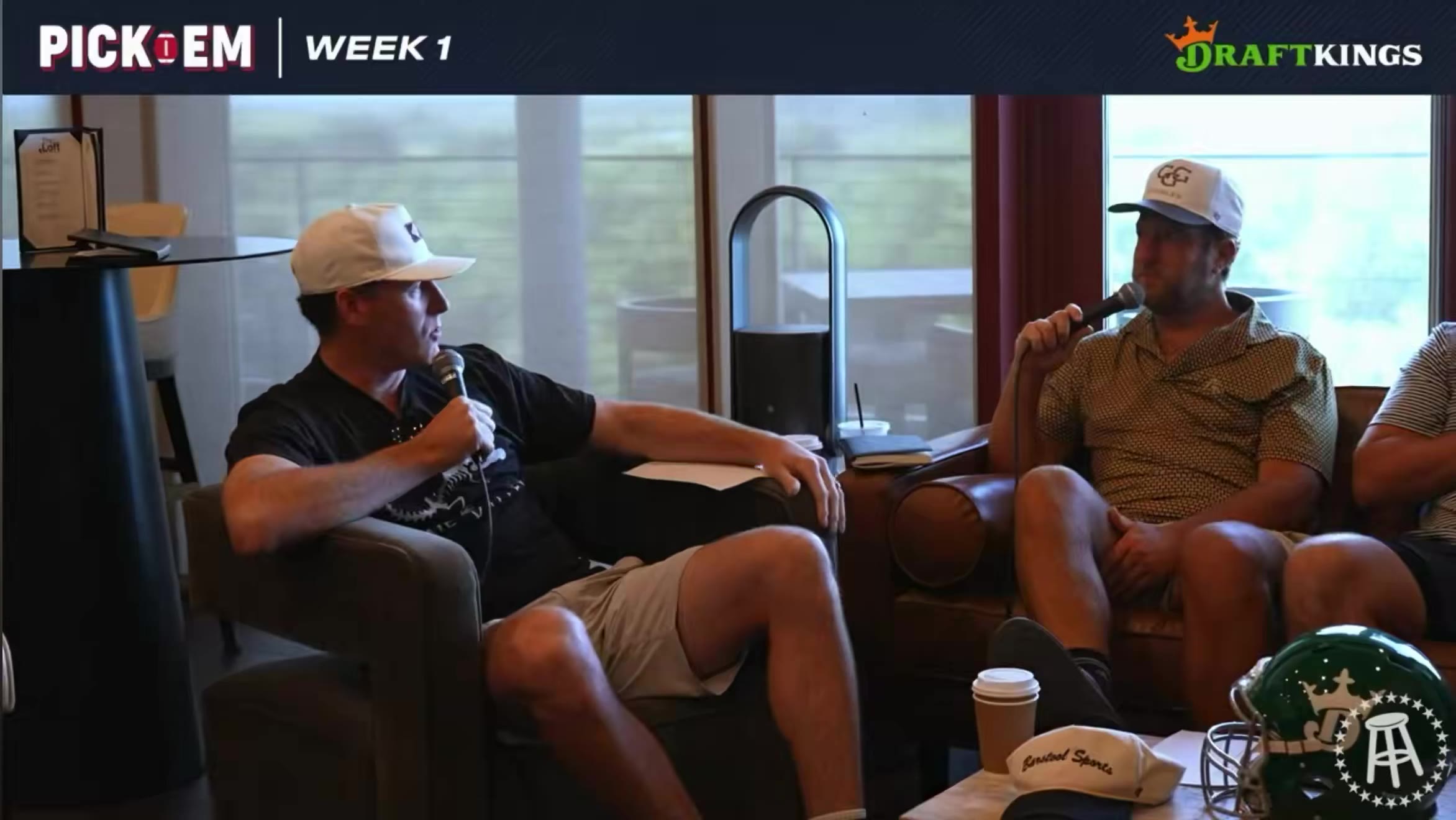 Four men sit on couches in a room with large windows, each holding a microphone; a football helmet, a coffee cup, and papers sit on the table in front of them, with a 'PICK EM WEEK 1' and DraftKings graphic overlaid on screen.
