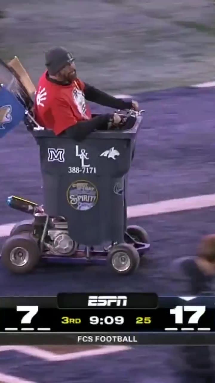 A person rides a motorized cart shaped like a large trash can onto a football field, waving to the crowd; on-screen scoreboard reads 7-17 in the 3rd quarter with 9:09 remaining.